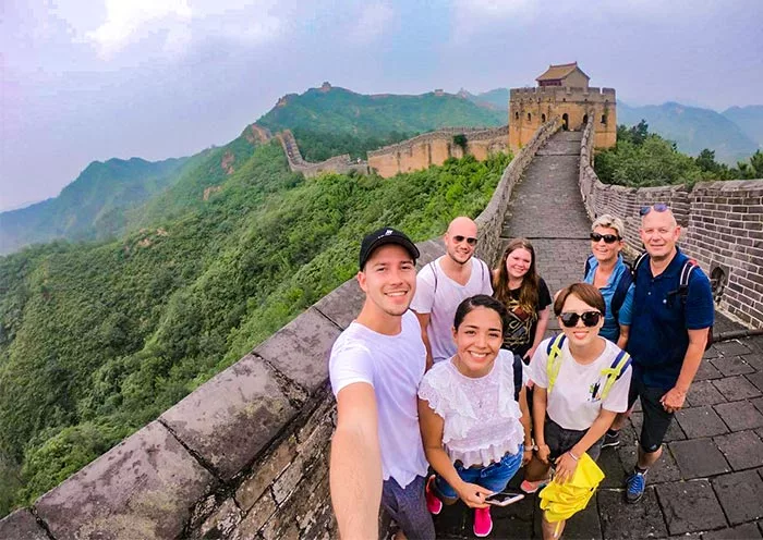 Private tour guests overlooking the Great Wall of China at sunset